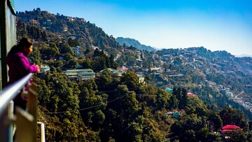 woman looking at the beautiful view of a town in mussoorie