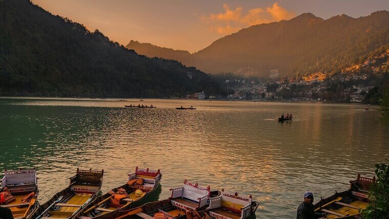 boats floating in nainital lake during sunset