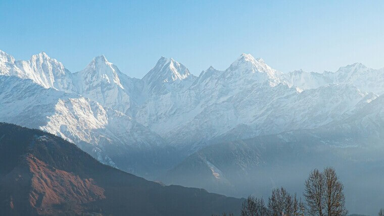 snow covered mountains in the distance in munsiyari