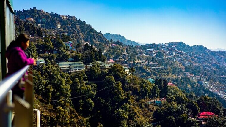 woman looking at the beautiful view of a town in mussoorie