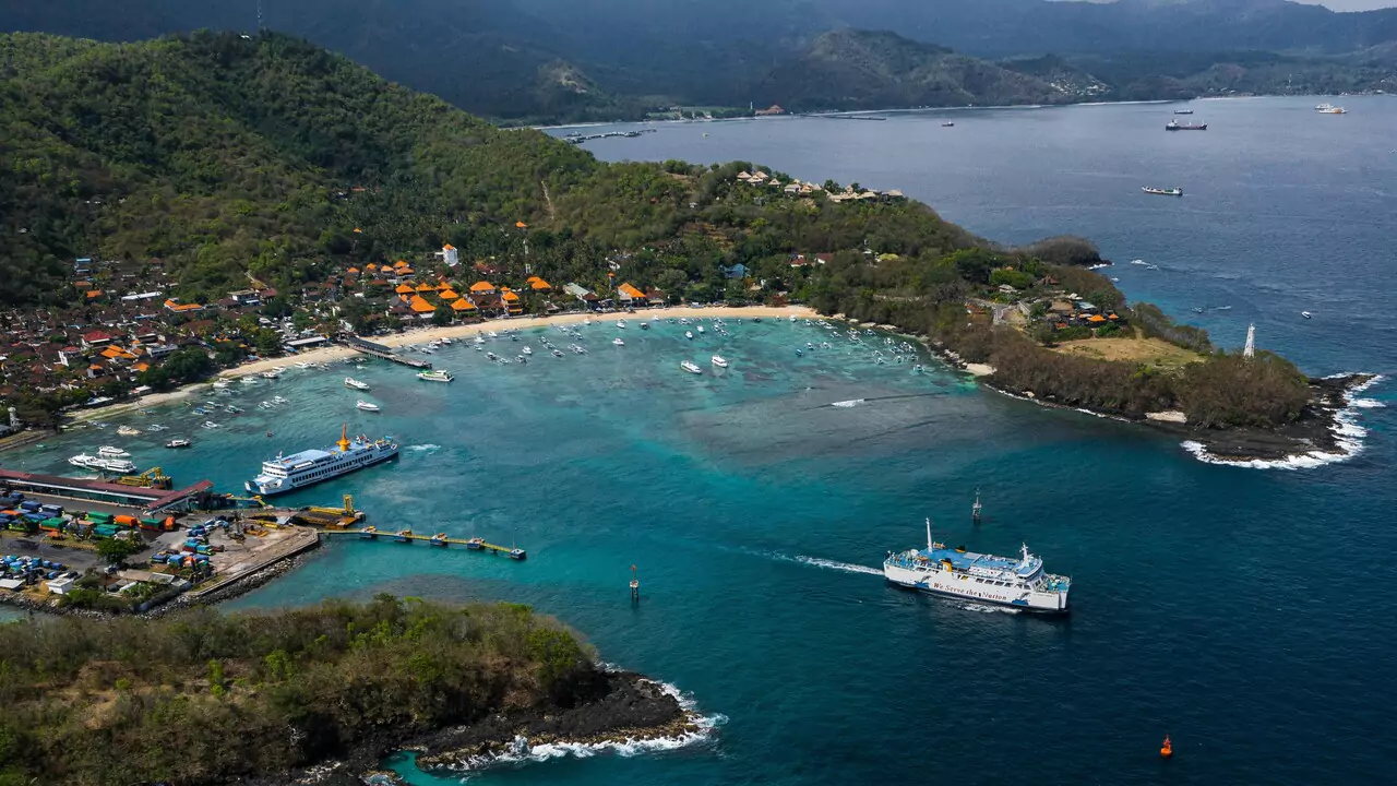 Aerial view of a small island surrounded by water, with a boat floating nearby.