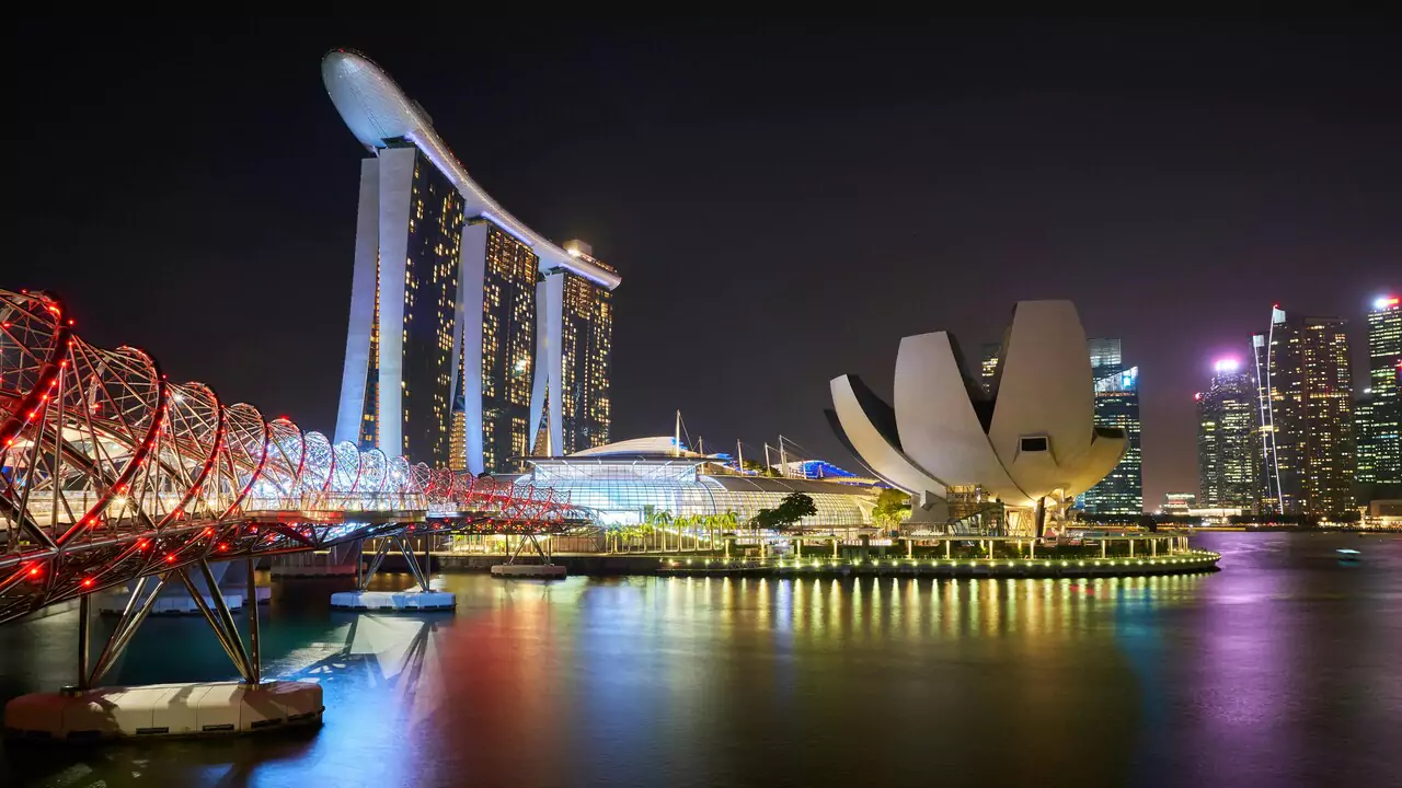 Singapore city skyline at night, featuring illuminated skyscrapers and a vibrant urban atmosphere.