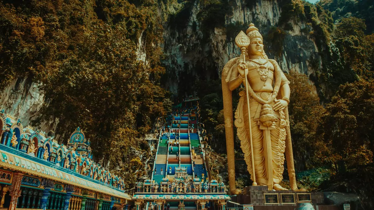 Murugan God statue is prominently placed on a mountain, offering a serene view of nature and the sky above.
