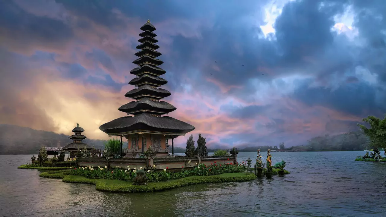 A tranquil temple encircled by water and trees, highlighting its natural beauty.