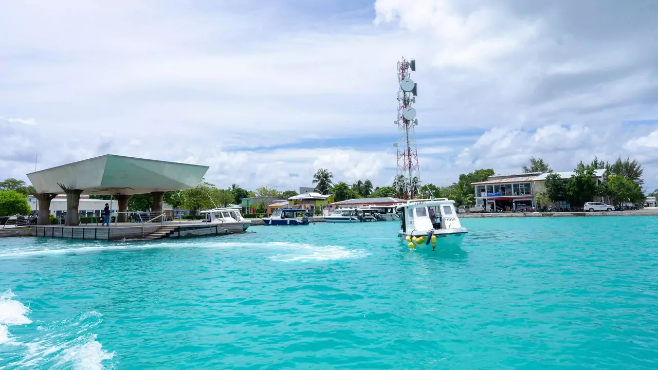 A boat moves smoothly on the water, close to a dock.