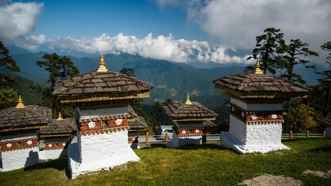 A breathtaking vista from the mountain peak, displaying rolling hills and distant ranges under a sunny sky.