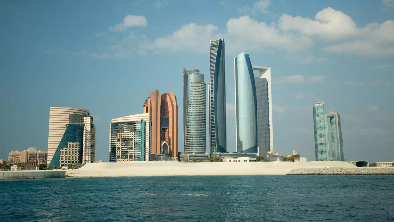 A skyline view of Abu Dhabi featuring modern skyscrapers and a clear blue sky.