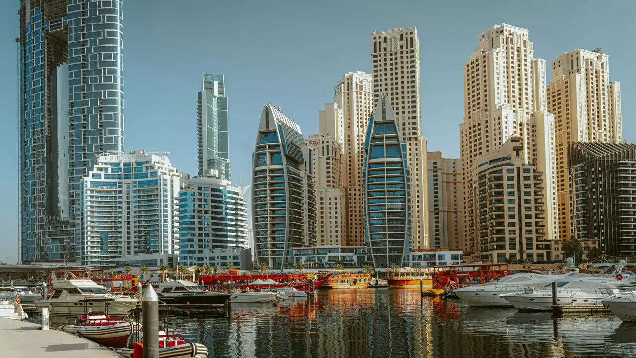 A marina filled with boats, surrounded by tall buildings, showcasing a vibrant urban waterfront scene.