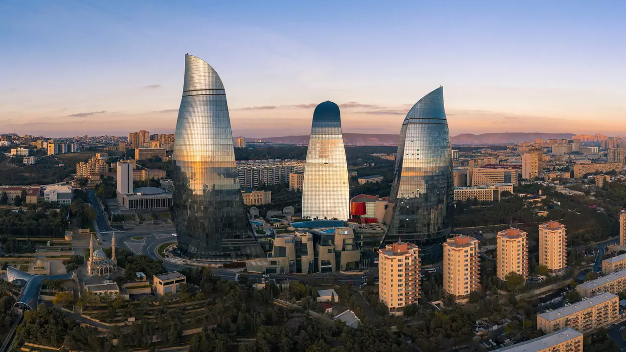 The Flame Towers in Baku, Azerbaijan, are three tall, modern skyscrapers shaped like flames, illuminated at night.