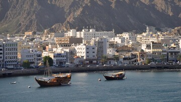 A coastal view of Oman city along the Gulf of Oman, showcasing its skyline and the blue waters