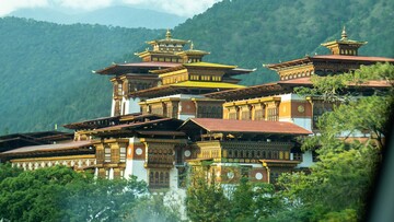 Large Buddhist temple with multiple red roofs, showcasing traditional architecture.
