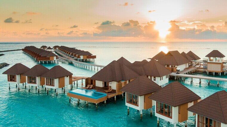 Luxurious Maldives resorts with overwater villas surrounded by crystal-clear ocean and lush tropical scenery.