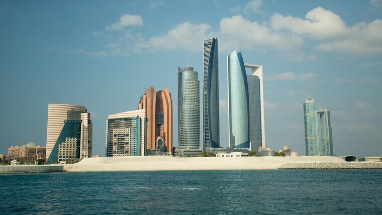 A skyline view of Abu Dhabi featuring modern skyscrapers and a clear blue sky.