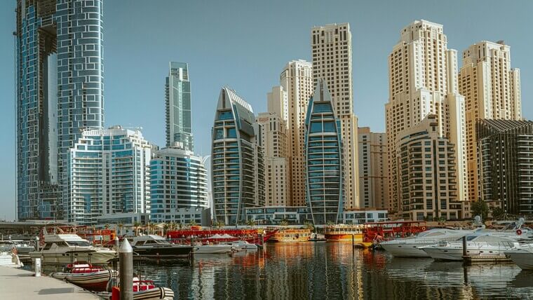 A marina filled with boats, surrounded by tall buildings, showcasing a vibrant urban waterfront scene.
