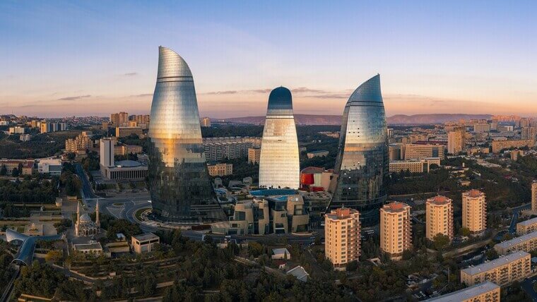 The Flame Towers in Baku, Azerbaijan, are three tall, modern skyscrapers shaped like flames, illuminated at night.